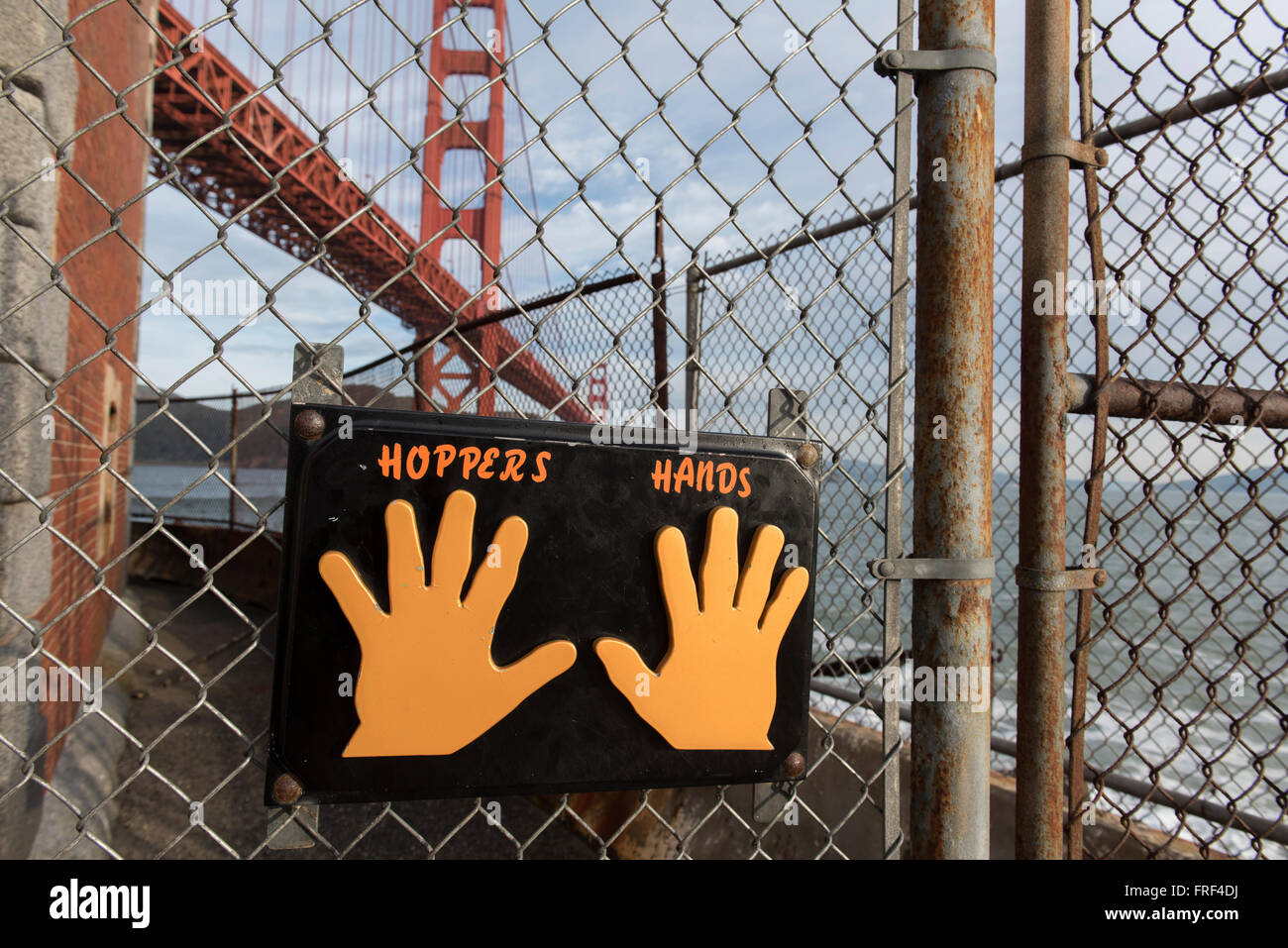 Les mains des trémies à la fin de la route au pied du Golden Gate Bridge, San Francisco, où l'ossature touch la clôture. Banque D'Images