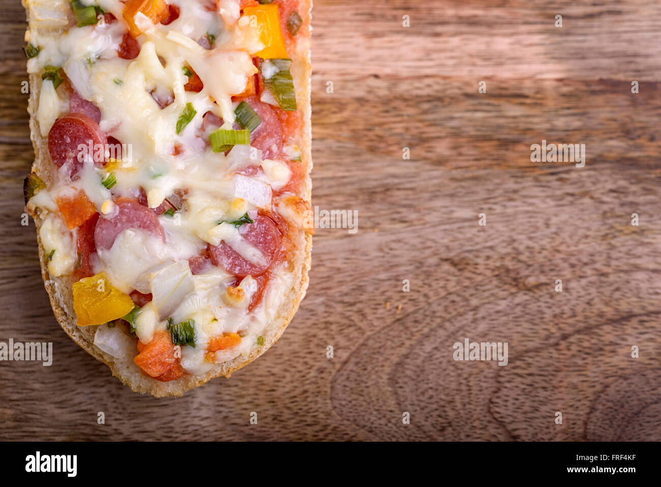 Baguette au four avec salami, fromage et légumes Banque D'Images