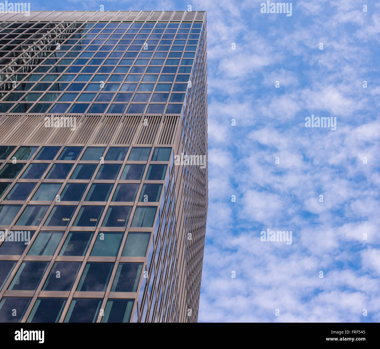 Façade de verre moderne avec des gratte-ciel ciel bleu et nuages blancs à l'arrière-plan. tourné à partir de ci-dessous. Banque D'Images