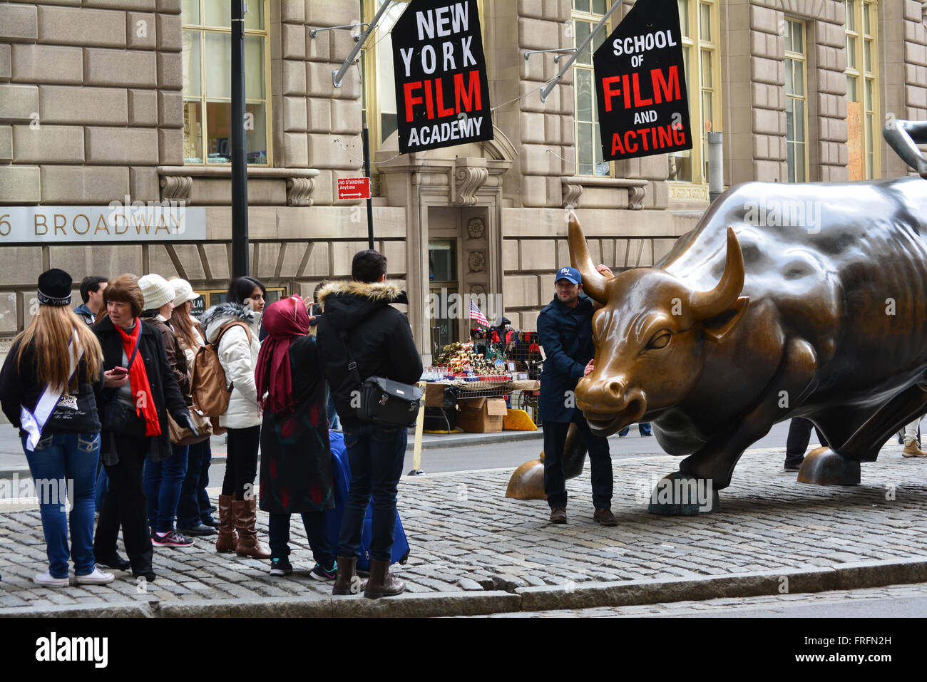 Les gens qui posent avec le Bull charge statue dans la ville de New York. Banque D'Images