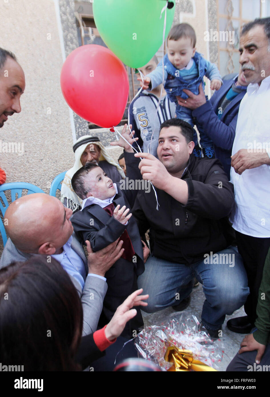 Naplouse, Cisjordanie, territoire palestinien. Mar 22, 2016. Dawabsha garçon palestinien Ahmed, 5 ans, qui a subi de graves brûlures lors d'un incendie criminel par de présumés assaillants juif sur sa maison familiale en juillet dernier et dans lequel son jeune frère, Ali et ses parents sont morts tous les deux, est accueilli par la famille après son retour d'Espagne où il a rencontré des stars du Real Madrid, à la maison de son grand-père dans le village cisjordanien de Duma, près de Naplouse, le 22 mars 2016. Ahmed Dawabsha son oncle et ses grands-parents sont retournés en Espagne, où ils ont rencontré les joueurs de l'équipe de football espagnole (crédit Image : © Nedal Eshtayah/APA Images vi Banque D'Images