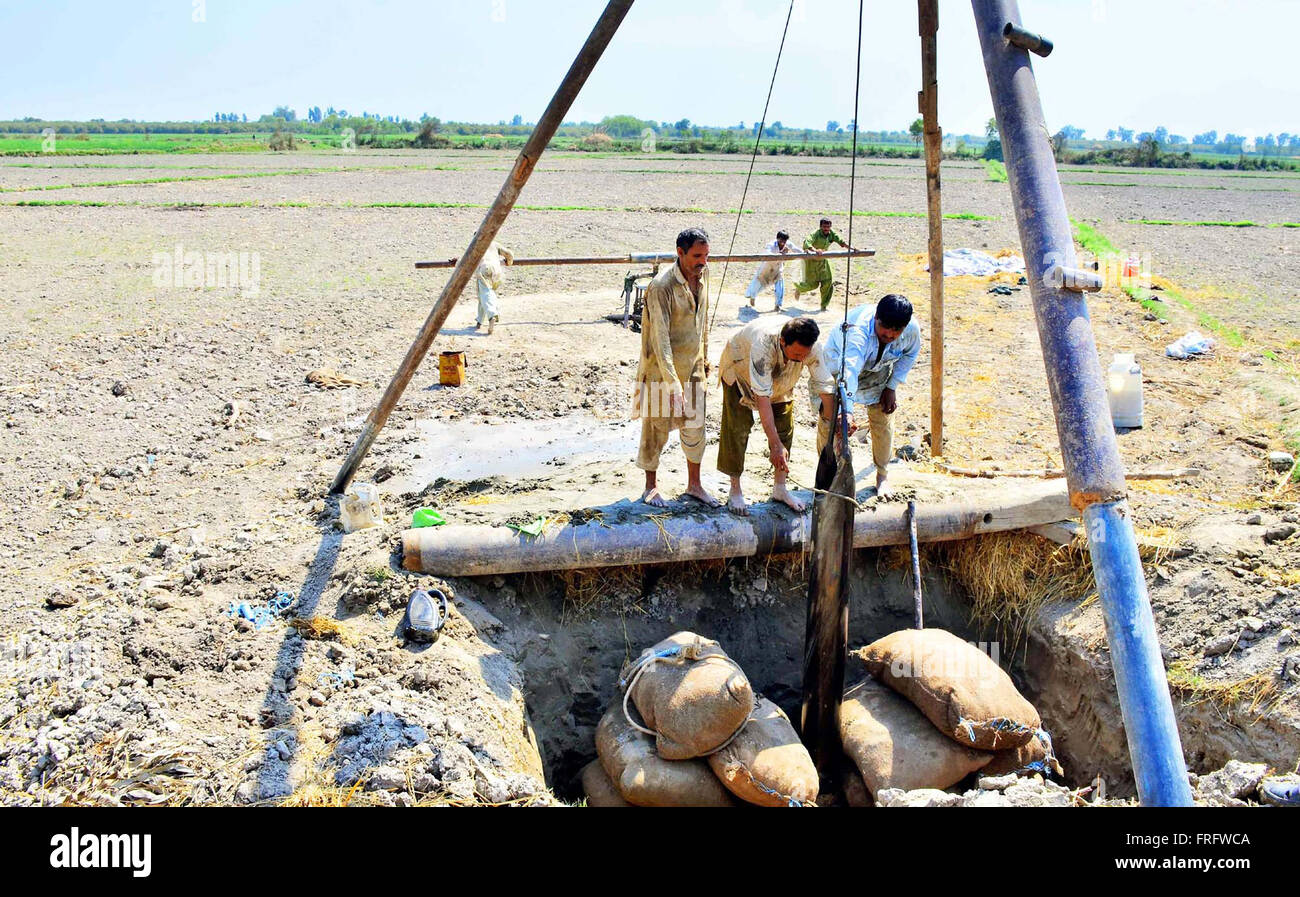 Travaux de forage qui sont occupés dans un tube et en utilisant des méthodes traditionnelles d'obtenir de l'eau souterraine à des fins d'irrigation à la veille de la Journée mondiale de l'eau à l'agriculture dans le domaine de Larkana Mardi, Mars 22, 2016. Banque D'Images