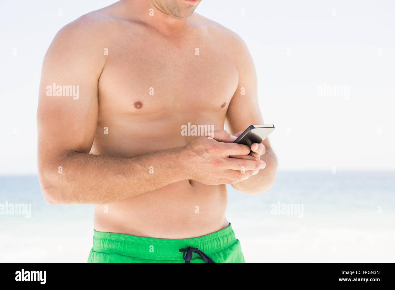 Man using smartphone sur la plage Banque D'Images
