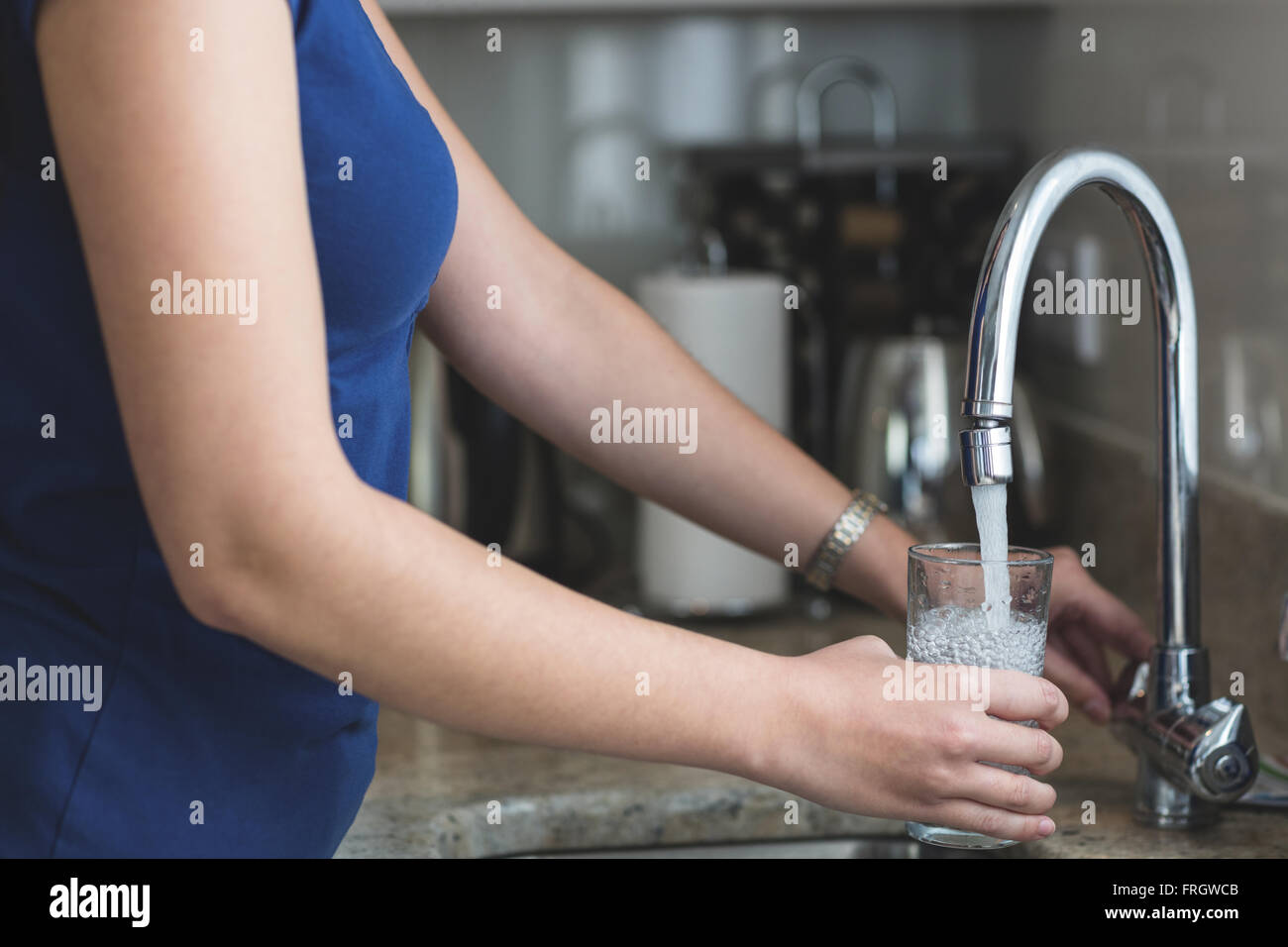 Close-up of woman washing un verre dans l'évier de cuisine Banque D'Images