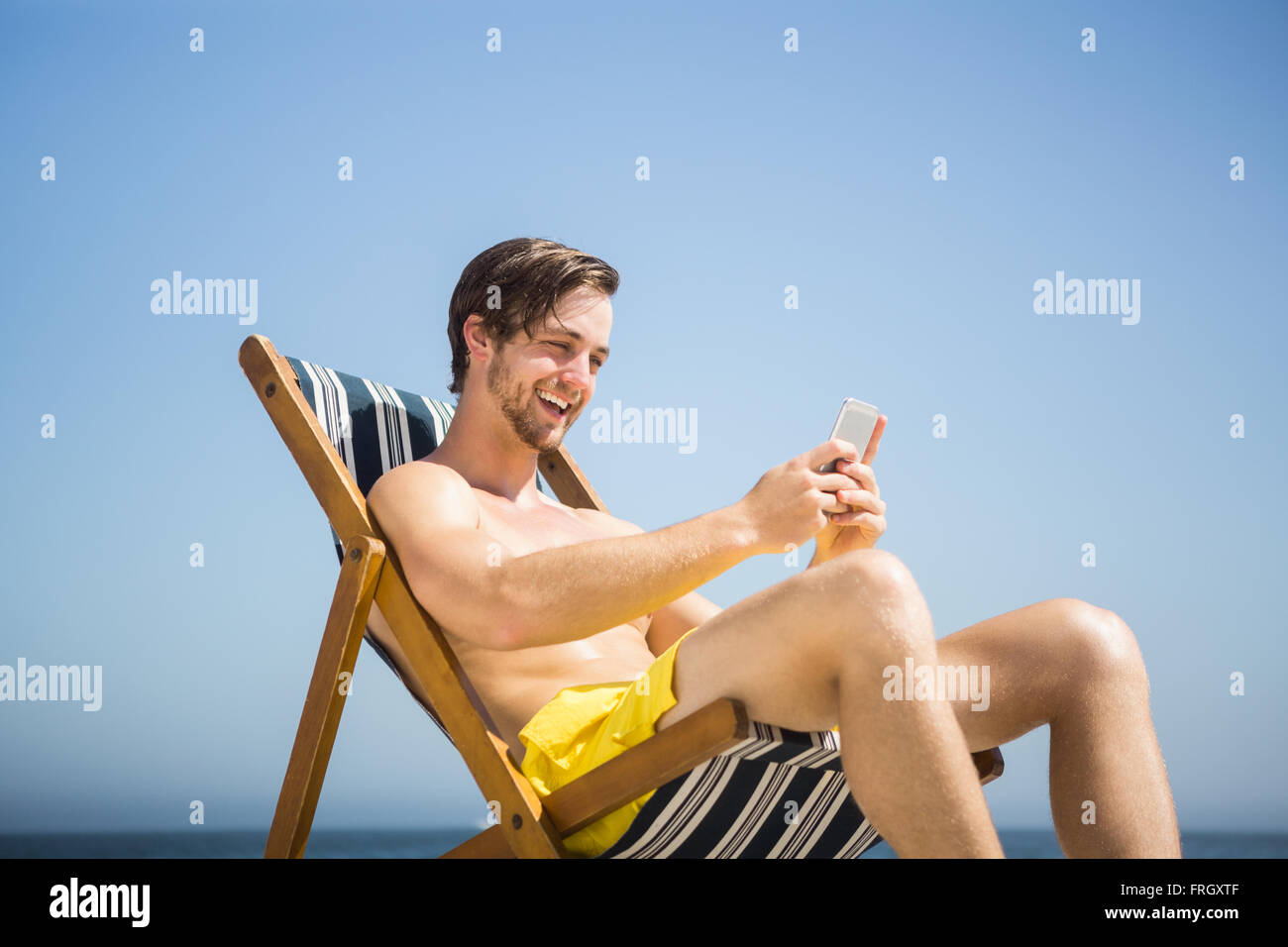 Man relaxing et using smartphone Banque D'Images