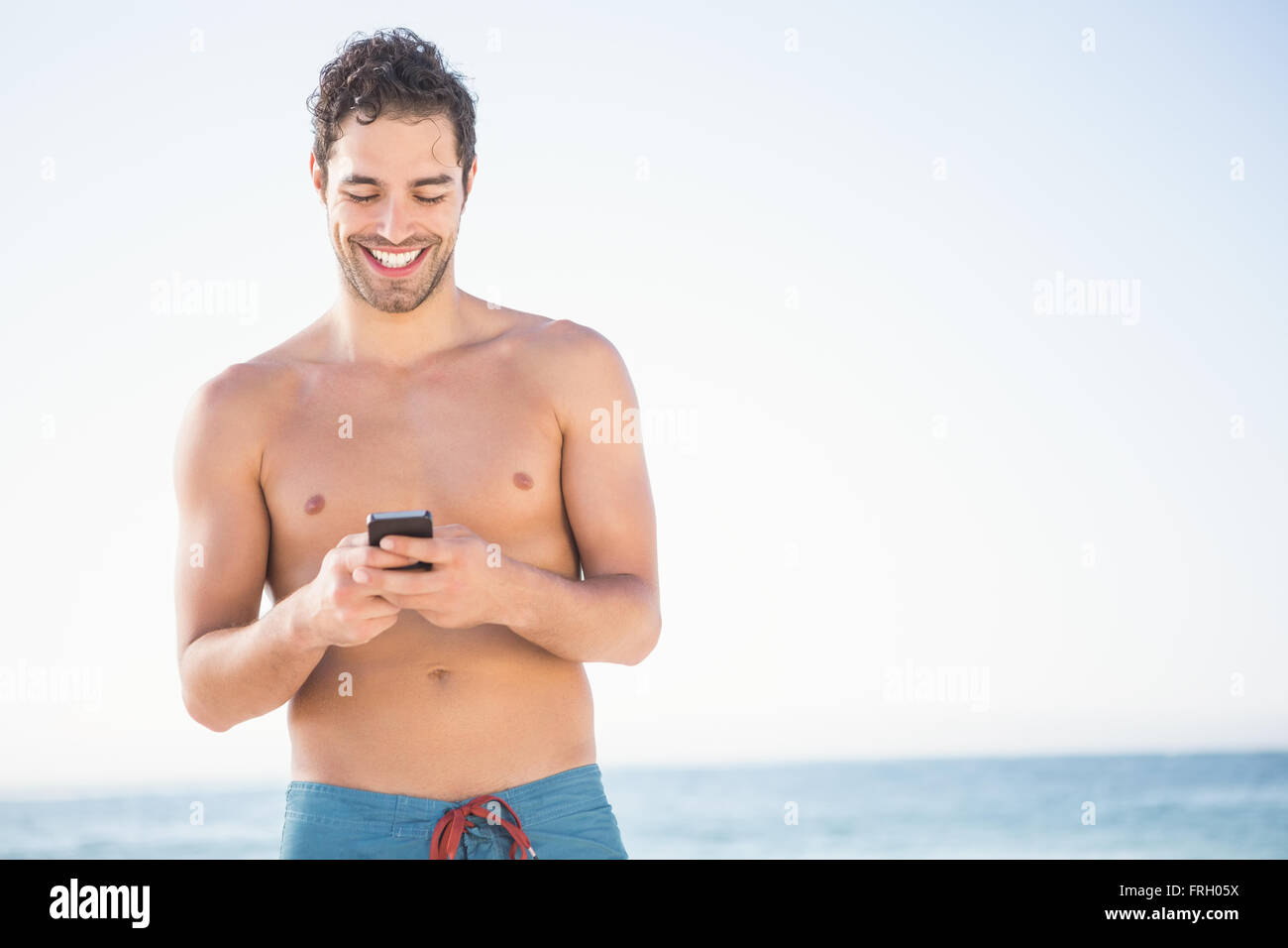 Smiling fit man using smartphone Banque D'Images