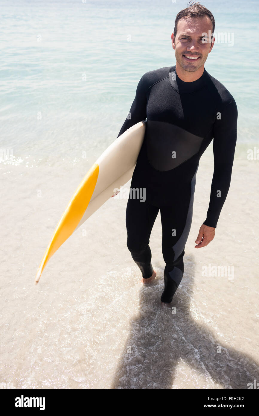 Surfer avec plaisir la tenue d'une planche de surf sur la plage Photo Stock  - Alamy