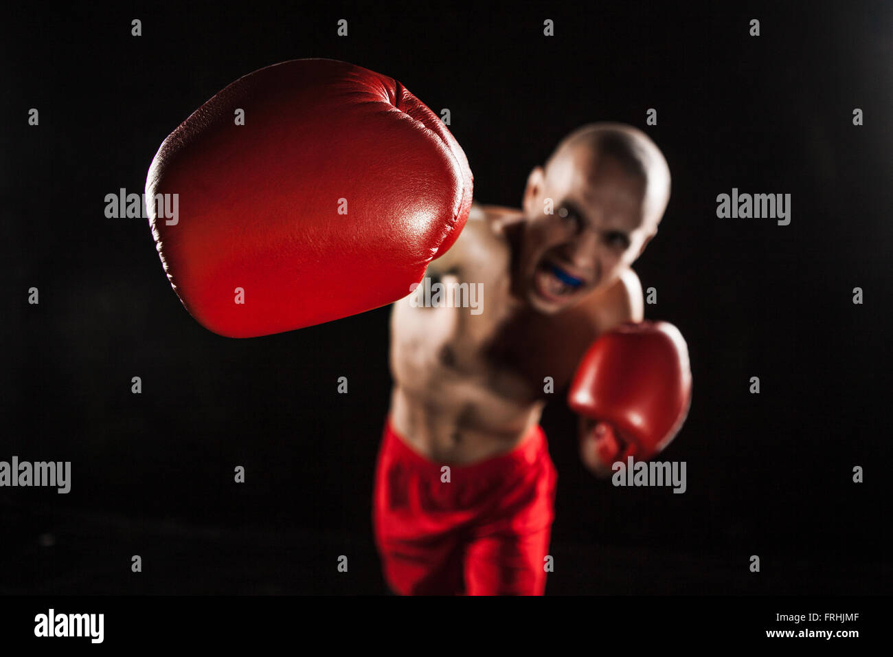 Le jeune homme le kickboxing sur noir avec kapa en bouche Banque D'Images