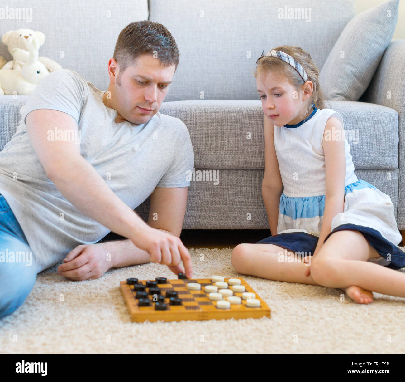 Petite fille et son père jouer aux dames. Banque D'Images