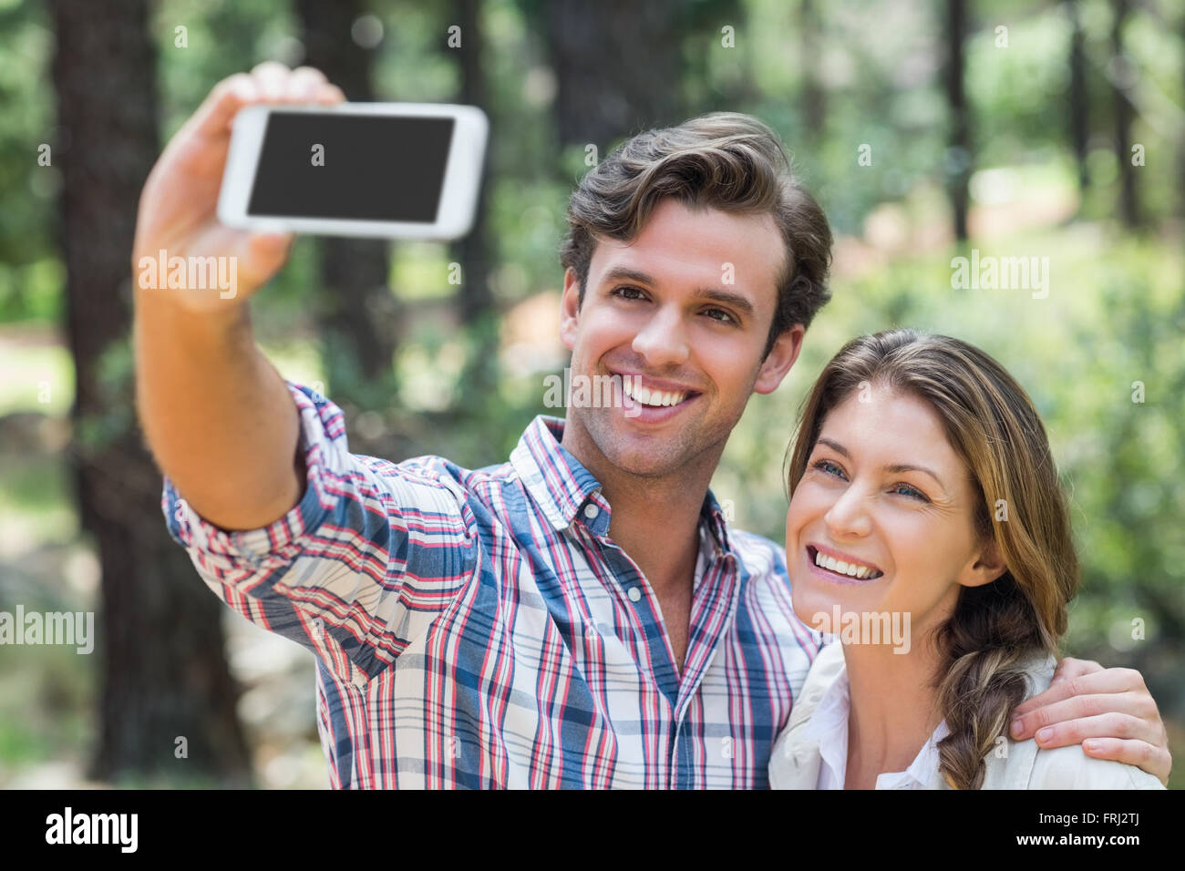 Couple heureux en cliquant sur smart phone avec selfies Banque D'Images