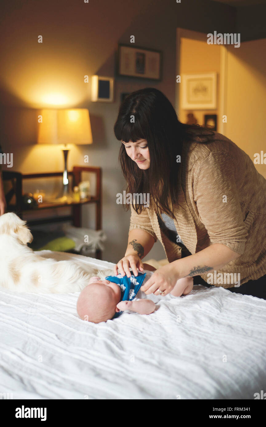 Changement de couche et armoire réajuster. La mère, le fils et l'animal. Banque D'Images