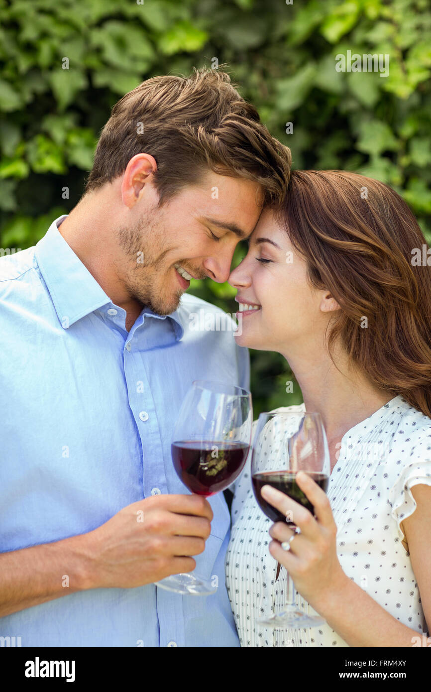 Couple holding wineglasses avec les yeux fermés en cour avant Banque D'Images