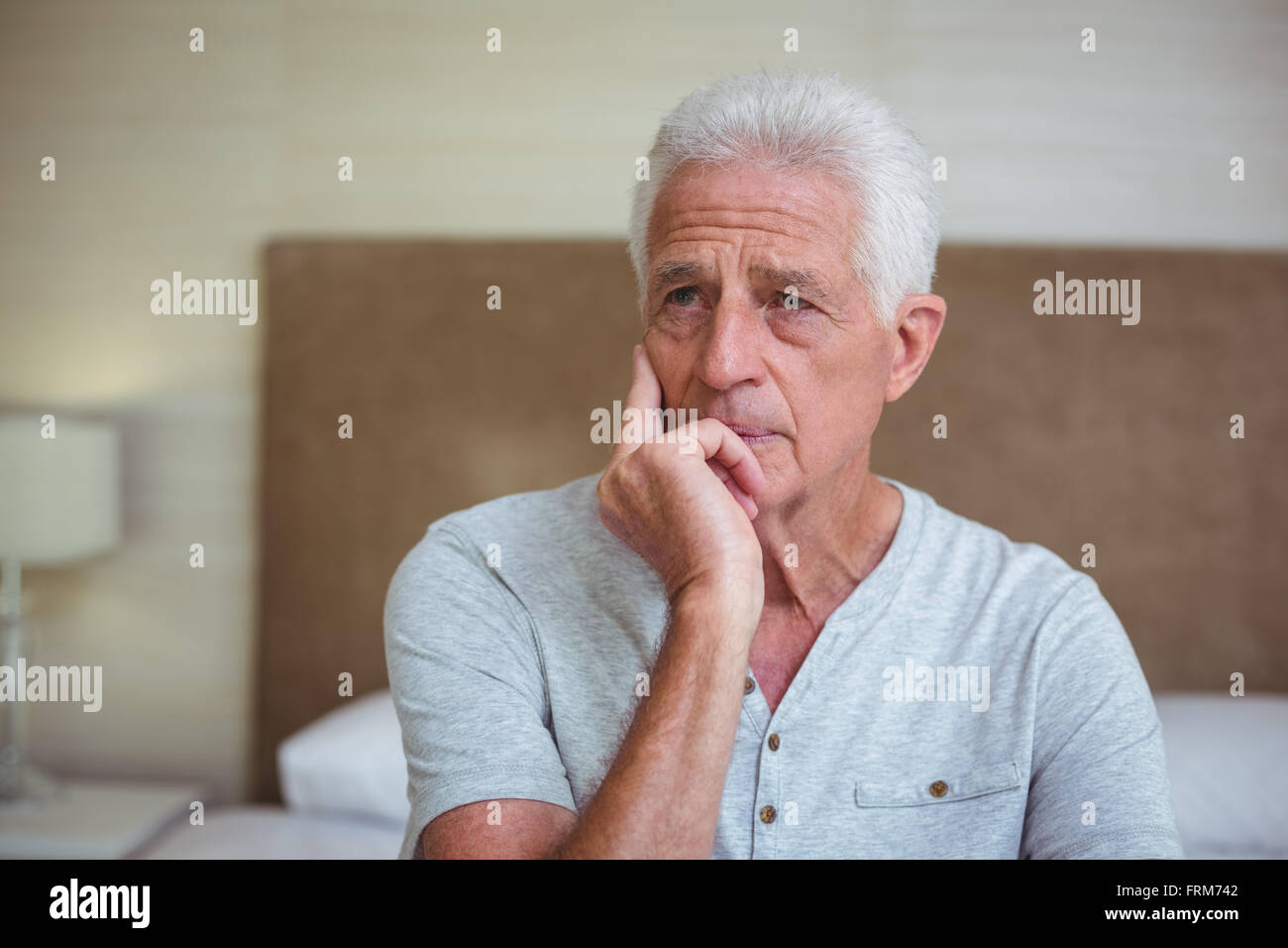 Happy man sitting on bed Banque D'Images