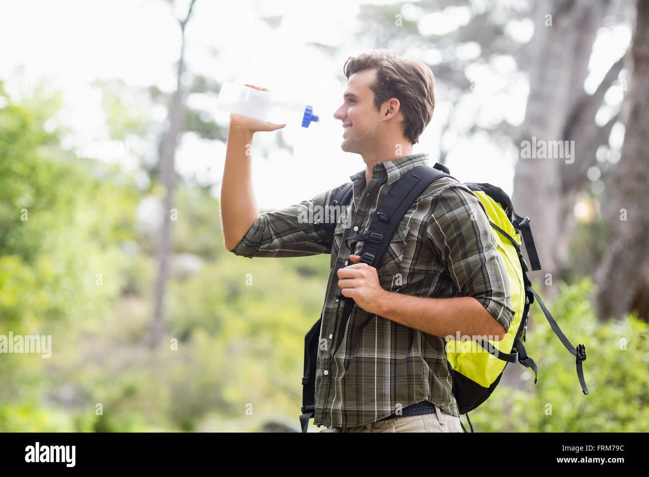 Jeune randonneur de l'eau potable et de standing in forest Banque D'Images