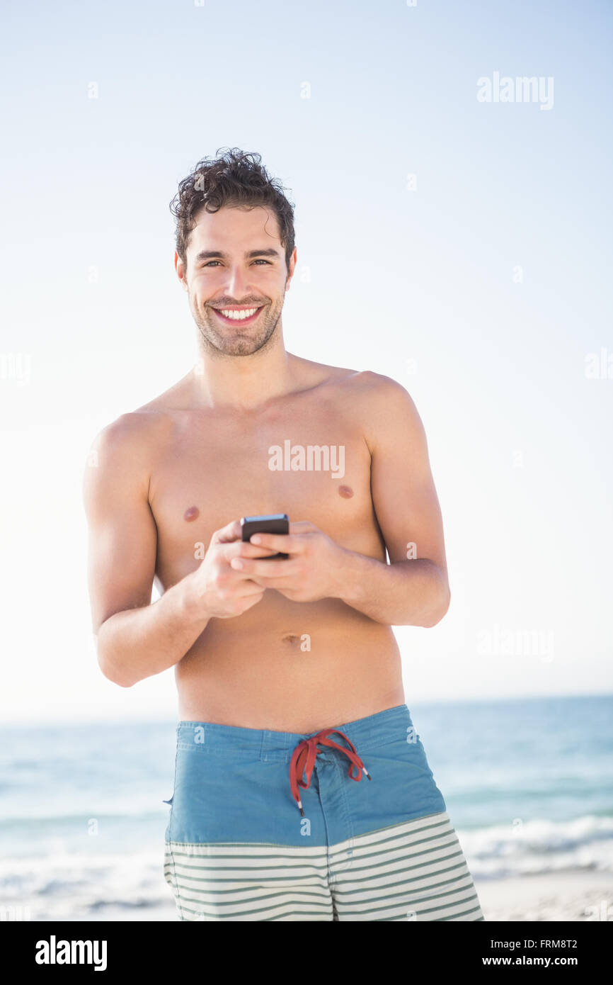 Smiling fit man using smartphone Banque D'Images
