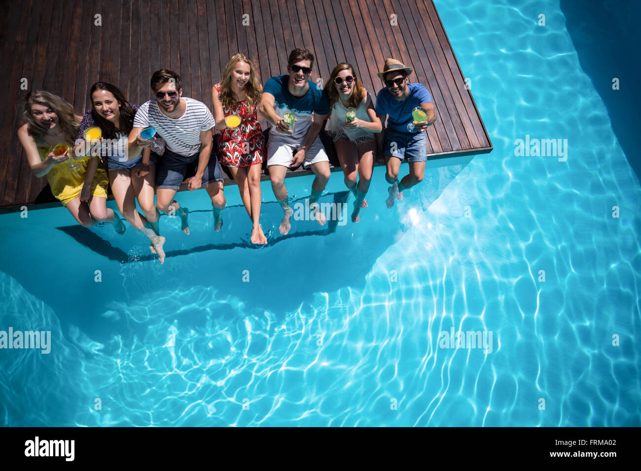 Happy friends sitting in swimming pool Banque D'Images