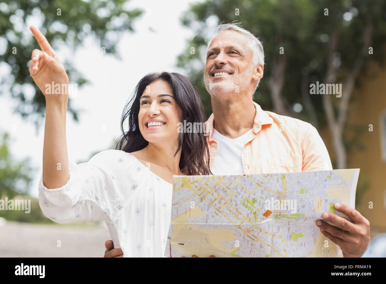 Femme en pointant à l'écart tout en man holding map Banque D'Images