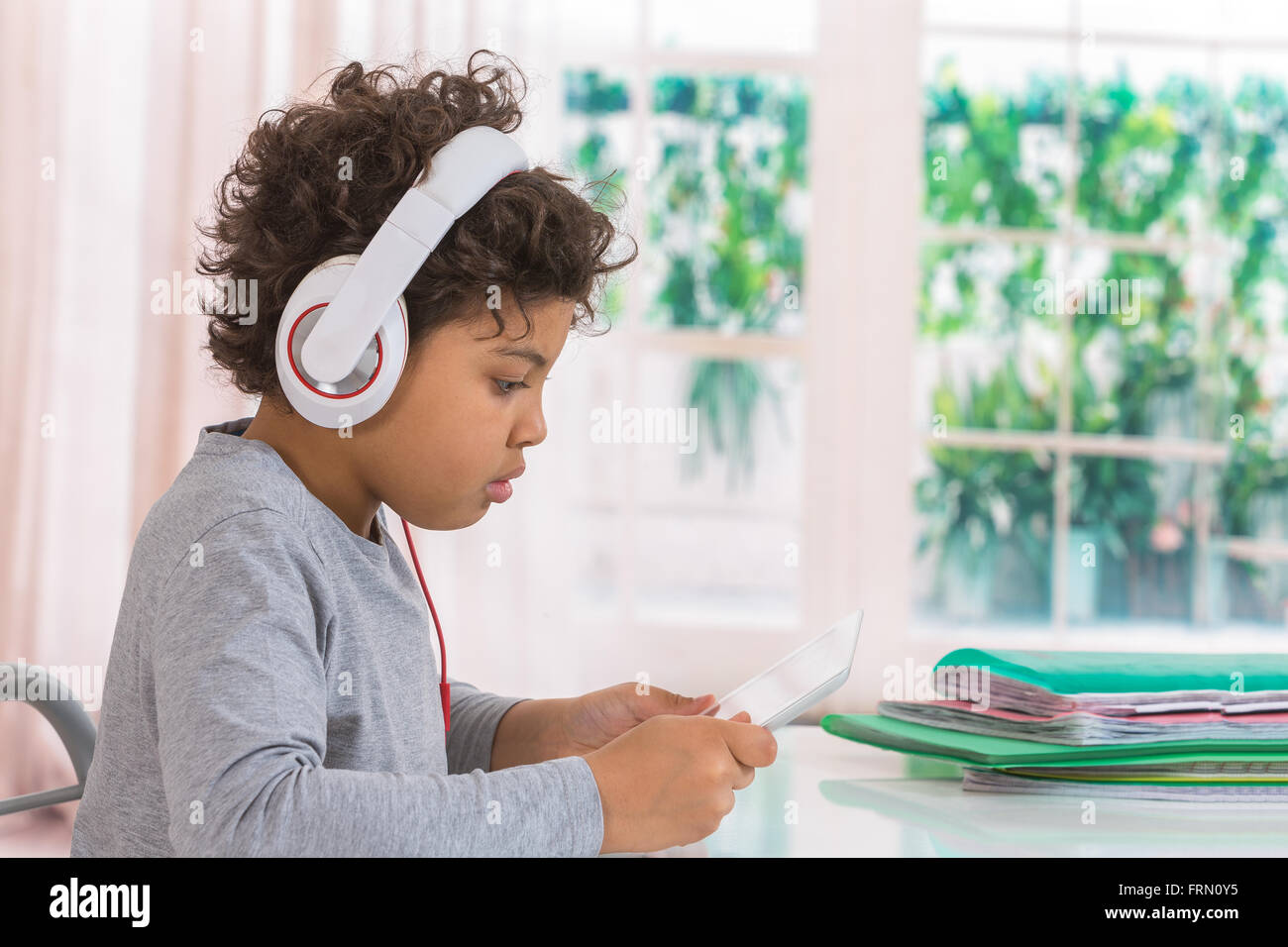 Cute teen boy écouter de la musique avec des écouteurs et tablette Banque D'Images