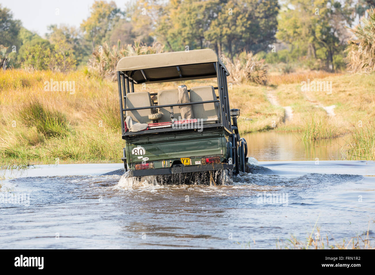 Safari en Jeep 4x4 traversant une rivière Ford, Sandibe Camp, par le Moremi, Okavango Delta, Botswana, Afrique du Sud Banque D'Images