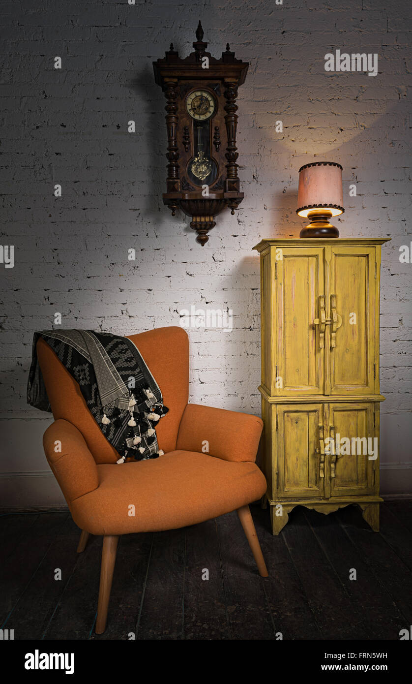 Still Life of vintage fauteuil orange, jaune meuble, sol horloge à pendule  et allumé la lampe de table sur un sol en bois Photo Stock - Alamy