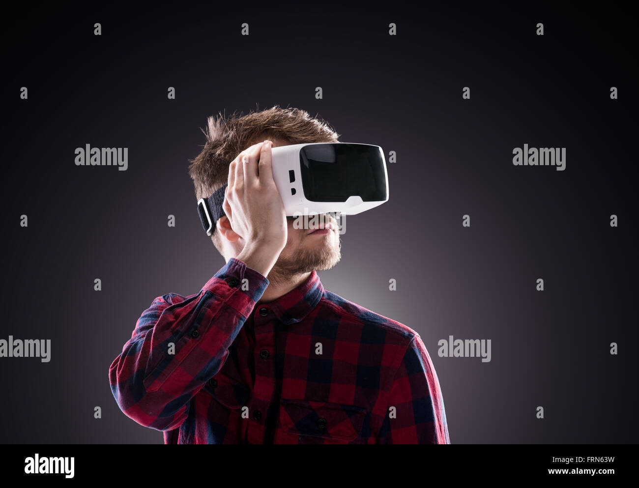 Homme portant des lunettes de réalité virtuelle. Studio shot, noir backgrou Banque D'Images