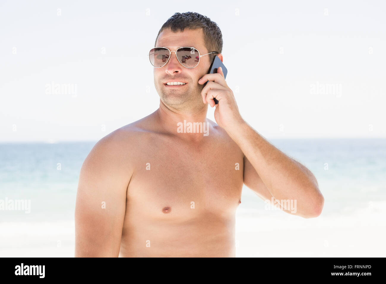 Homme au téléphone à la plage Banque D'Images