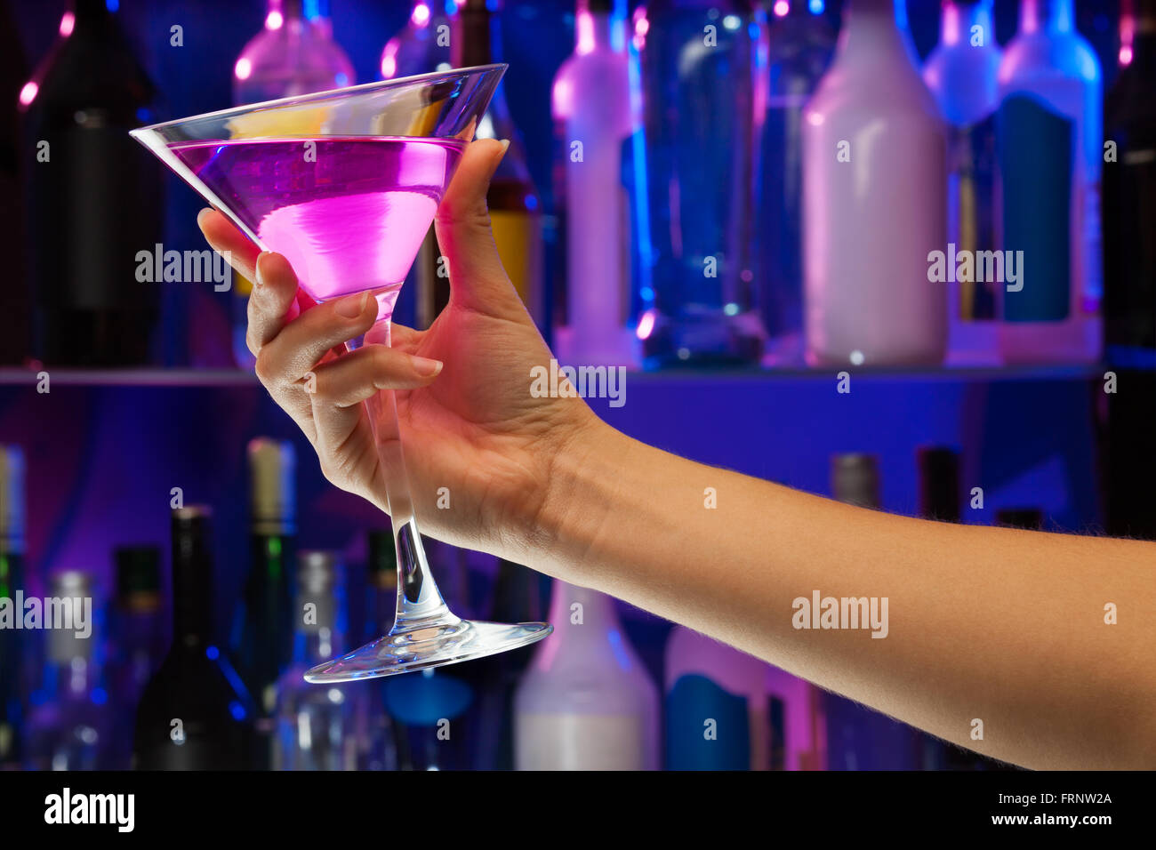 Boire de l'alcool dans la main à l'intérieur de verre femme bar Banque D'Images