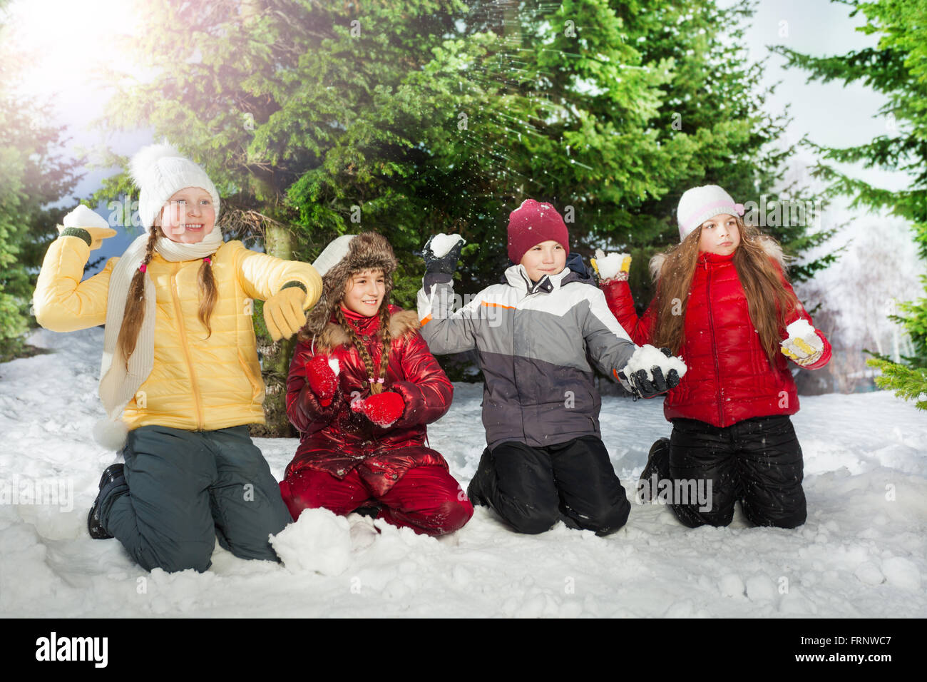 Happy kids lançant des boules de neige dans la forêt enneigée Banque D'Images