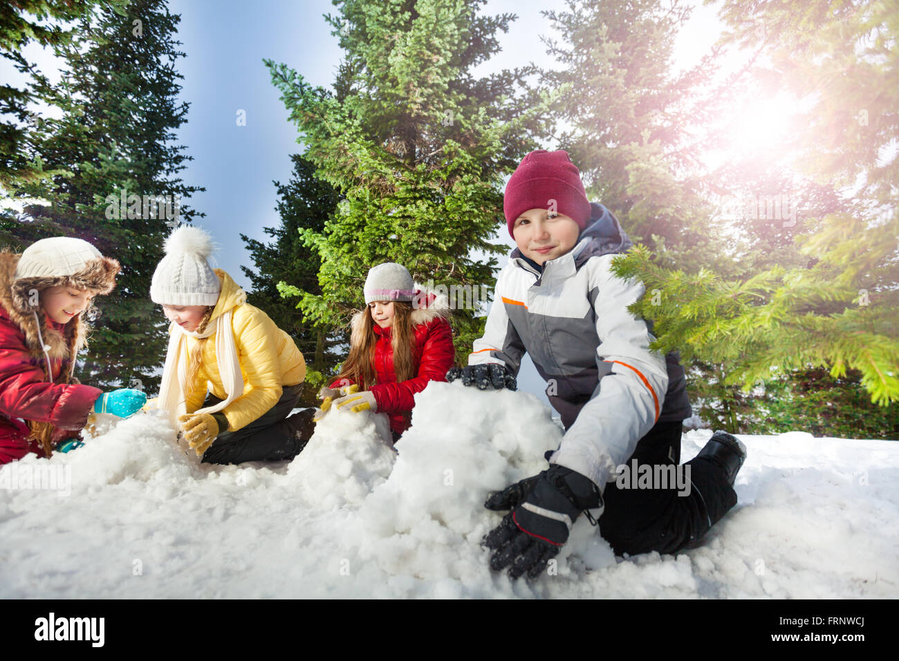 Quatre kids snowman au belle forêt Banque D'Images