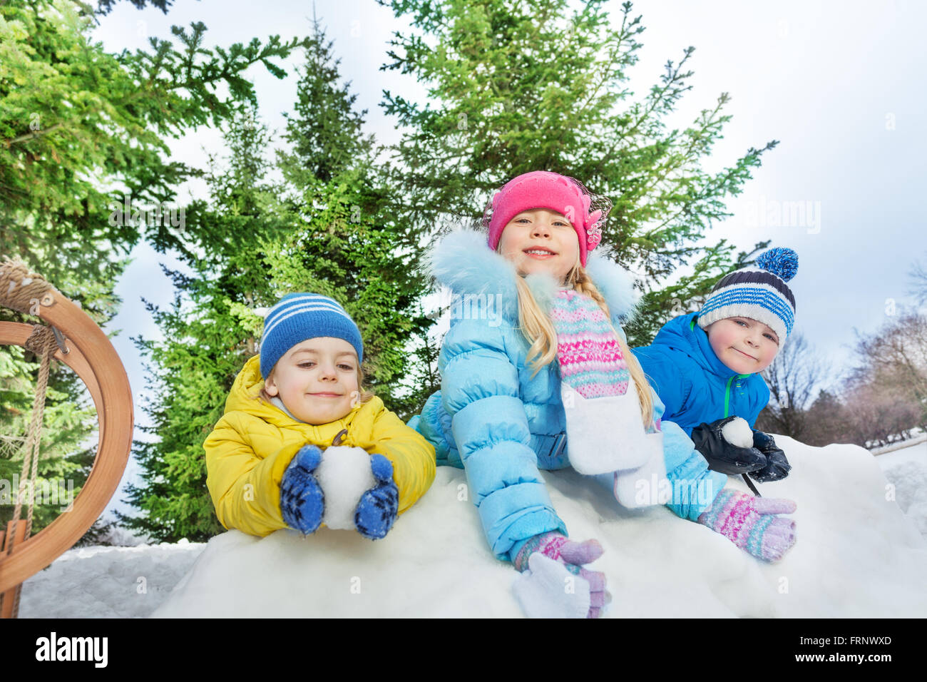 Trois petits enfants jouer snowball fight Banque D'Images