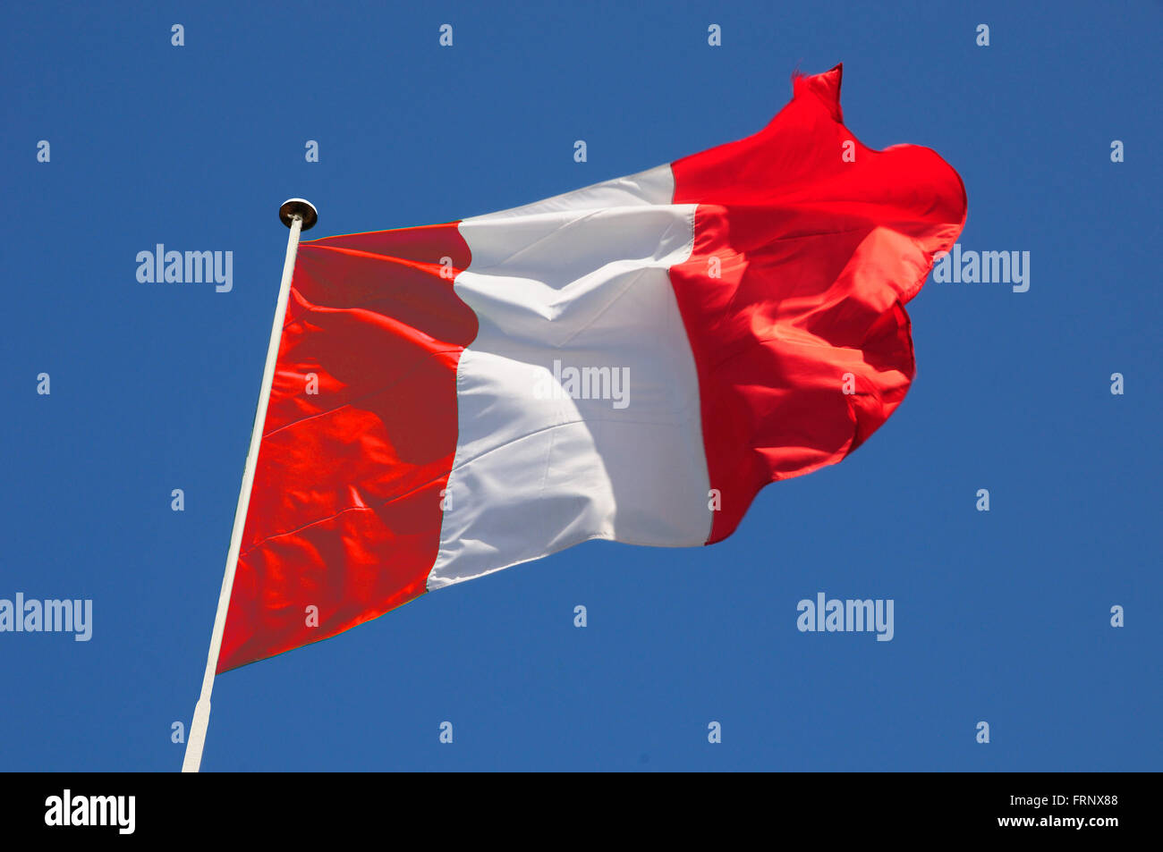 Drapeau péruvien voletant dans la brise d'une rapide contre un ciel bleu. Banque D'Images