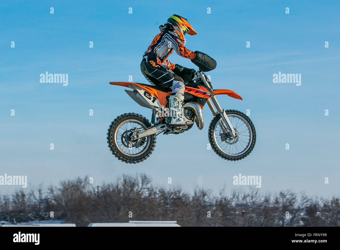 Moto Racer haut vol sur fond de ciel bleu au cours de l'hiver la Coupe du motocross Banque D'Images