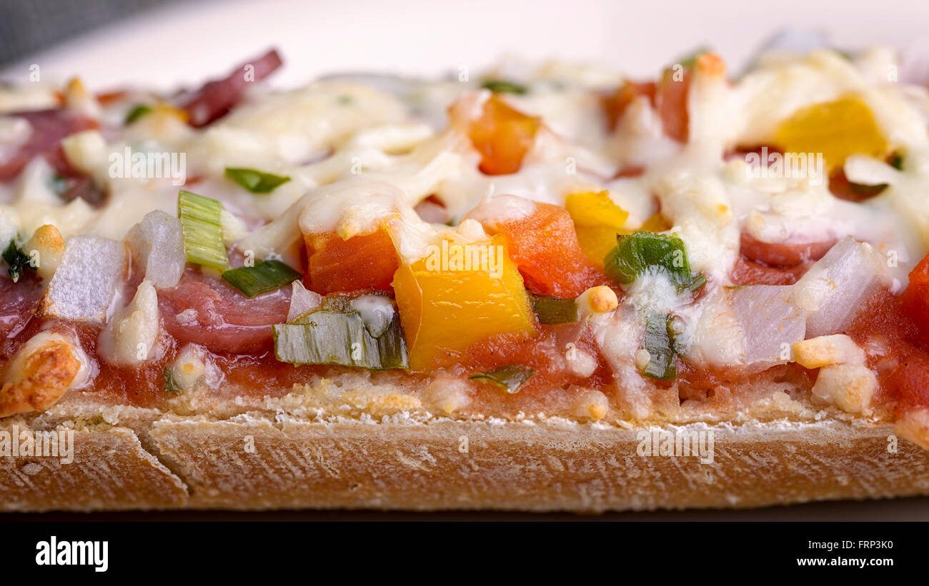 Baguette au four avec salami, fromage et légumes Banque D'Images