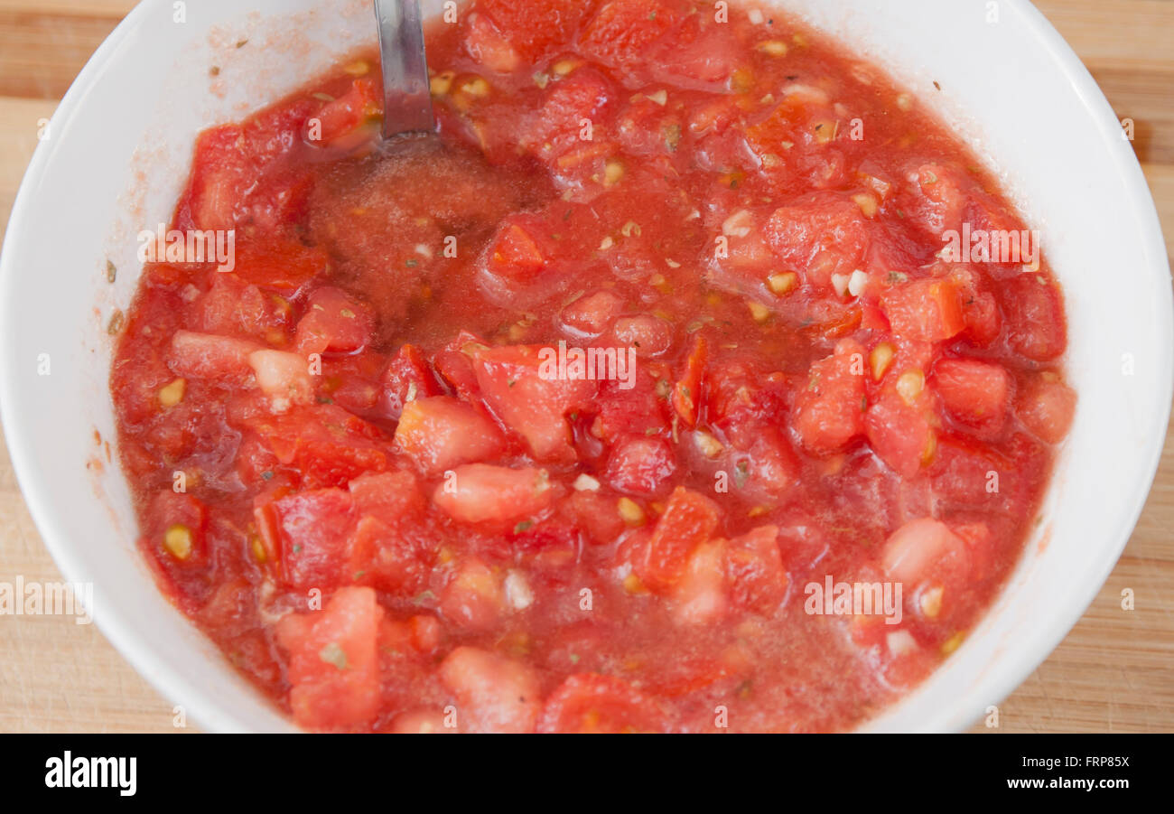 Couper la tomate avec l'huile, l'ail et l'origan Banque D'Images