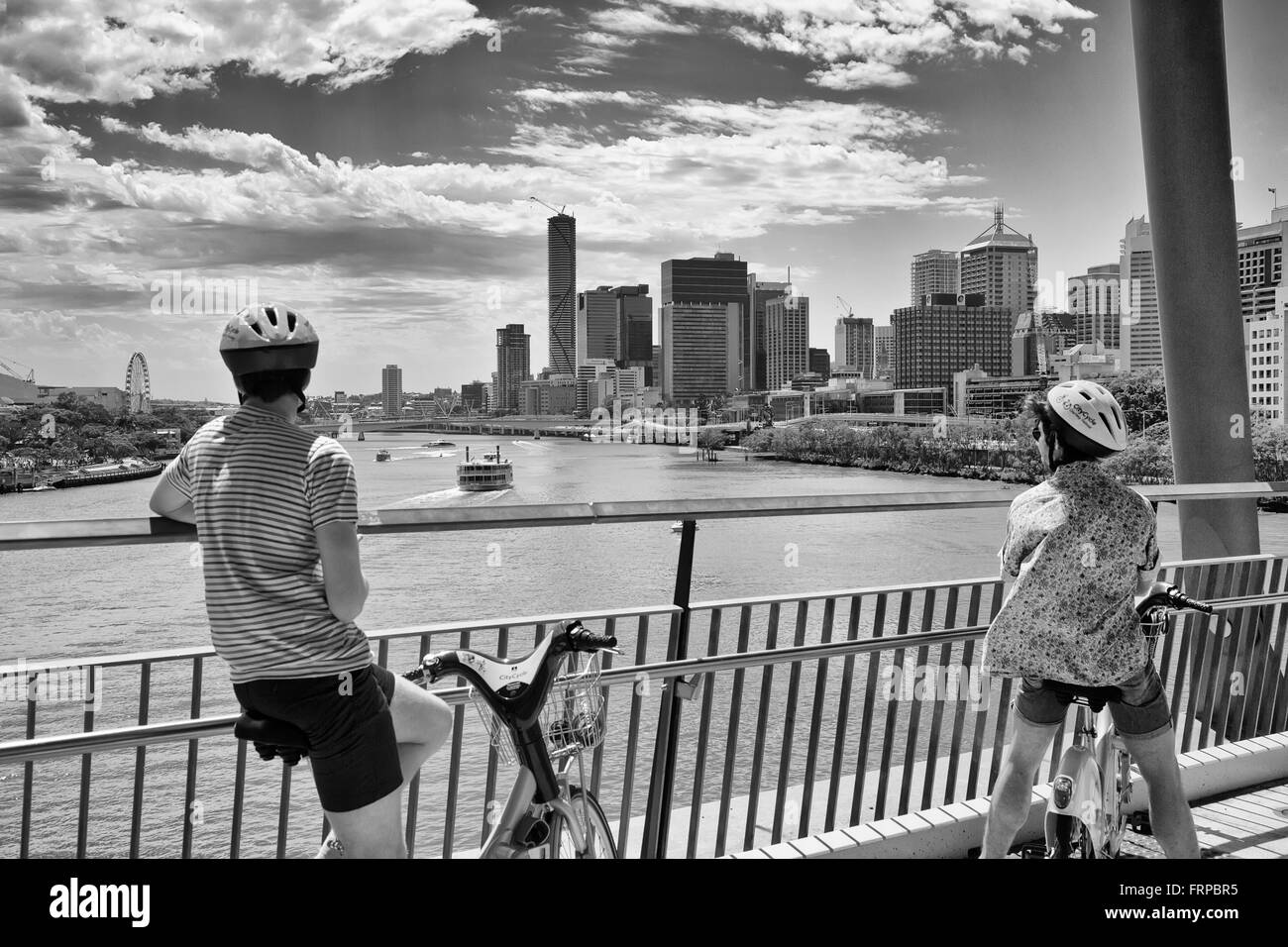 Les cyclistes s'arrêter pour admirer la vue de la ville au-delà de la rivière de Brisbane sur le pont de Bonne Volonté Banque D'Images