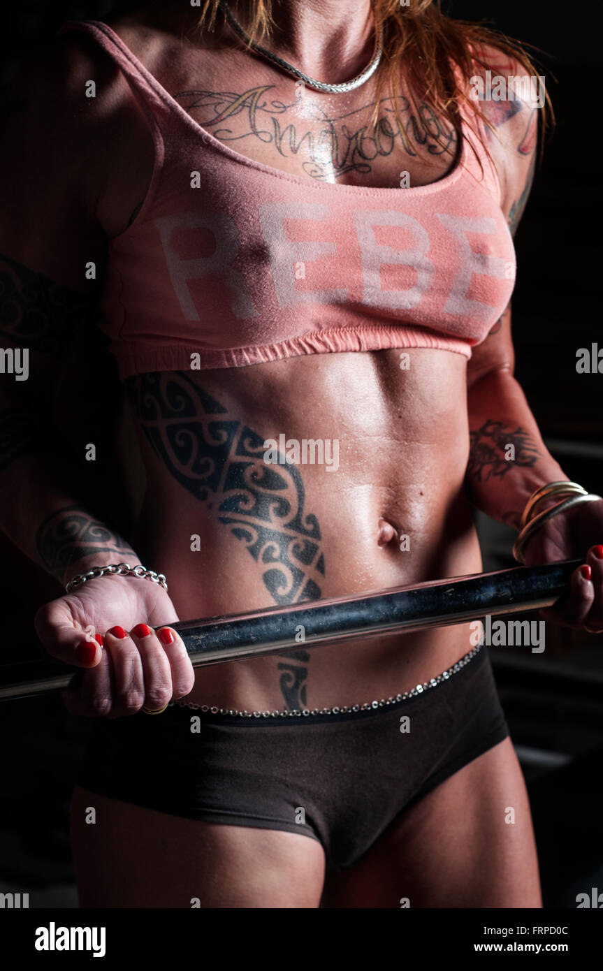 Femme tatouée le levage de poids Banque D'Images