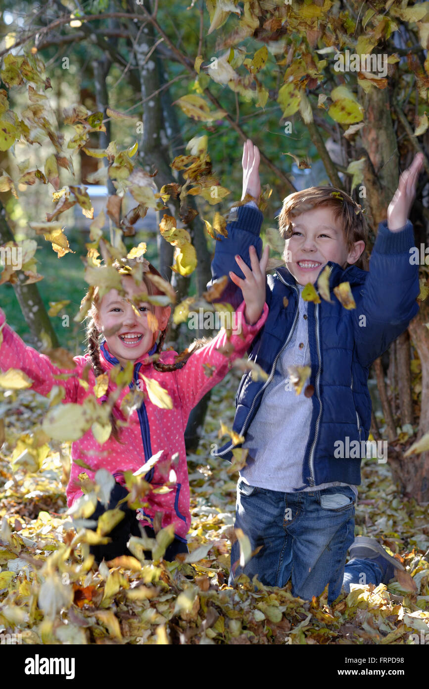 Les enfants qui jouent avec les feuilles d'automne, Bavière, Allemagne Banque D'Images