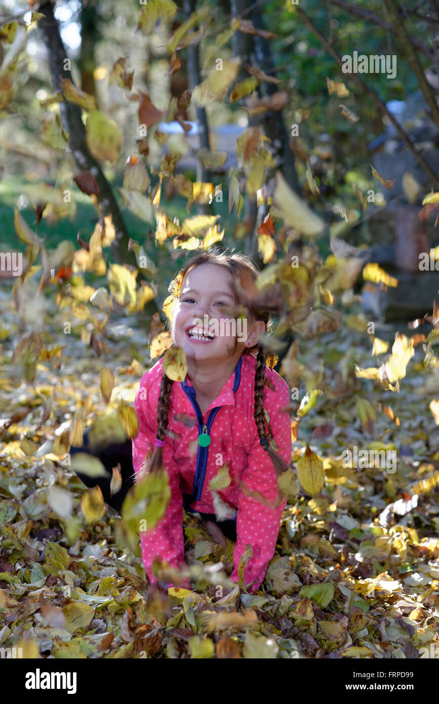 Fille jouant avec les feuilles d'automne, Bavière, Allemagne Banque D'Images