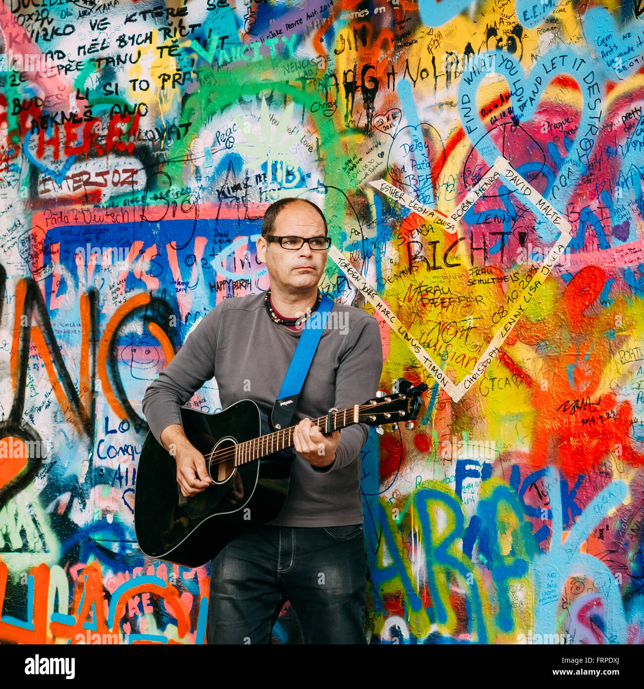Prague, République tchèque - Le 10 octobre 2014 : l'homme chante des chansons des Beatles John Lennon, près de mur. Mur est rempli de John Lennon inspir Banque D'Images