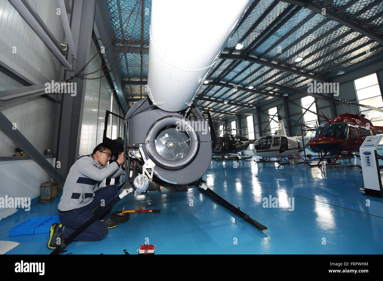 Ningbo, province de Zhejiang en Chine. Mar 23, 2016. Techniciens maintenir un hélicoptère Robinson RAVEN pour les clients au centre de Shanghai de Yida Aero dynamique générale Tech. Company (GDAT), un aéronef général magasin 5S, à la zone portuaire sous douane Meishan à Ningbo, province de Zhejiang en Chine orientale, le 23 mars 2016. L'aéronef magasin 5S, qui a été inaugurée le 8 avril 2015, a vendu 88 hélicoptères par ici. Le magasin fournit plus de 20 types d'hélicoptères avec prix de vente entre 3 à 100 millions de yuans (1,38 millions de dollars US 461,400-15). Credit : Huang Zongzhi/Xinhua/Alamy Live News Banque D'Images