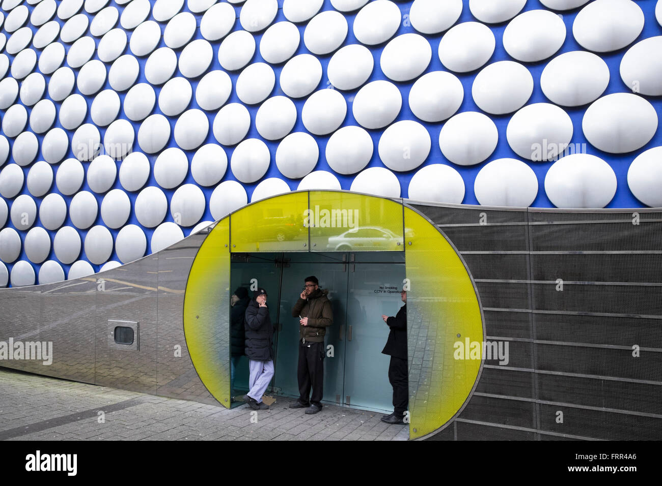 Trois hommes à l'abri d'une porte à Selfridges magasin, Birmingham, West Midlands, England, UK Banque D'Images