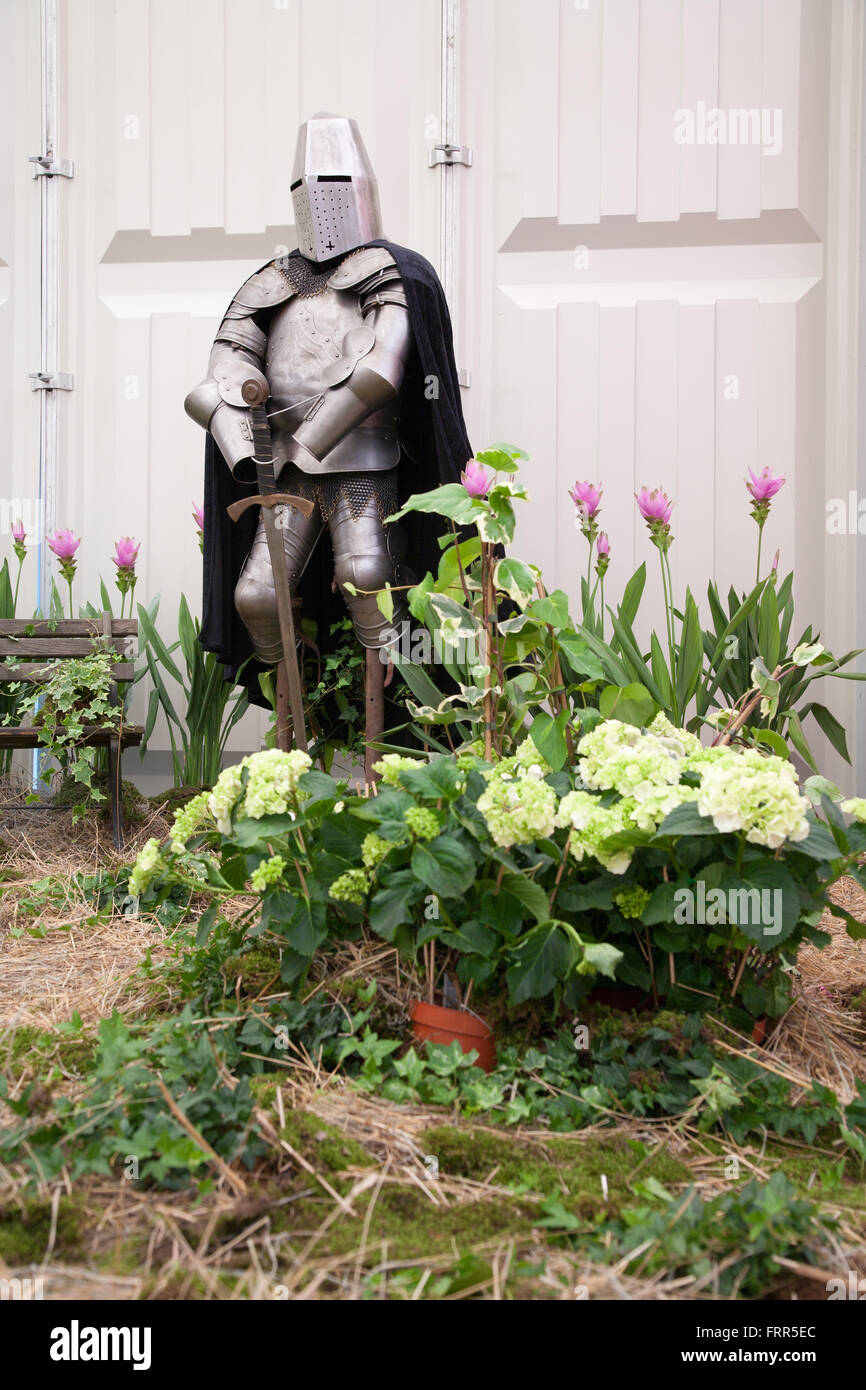 Scène médiévale avec un chevalier dans un jardin de fleurs Banque D'Images