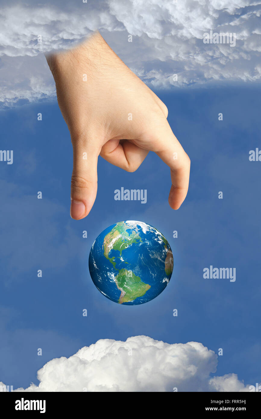 La main de Dieu en mettant la terre dans le ciel dans le ciel entre les nuages, symbole de foi et de religion. Les images utilisées par l'auteur. Banque D'Images