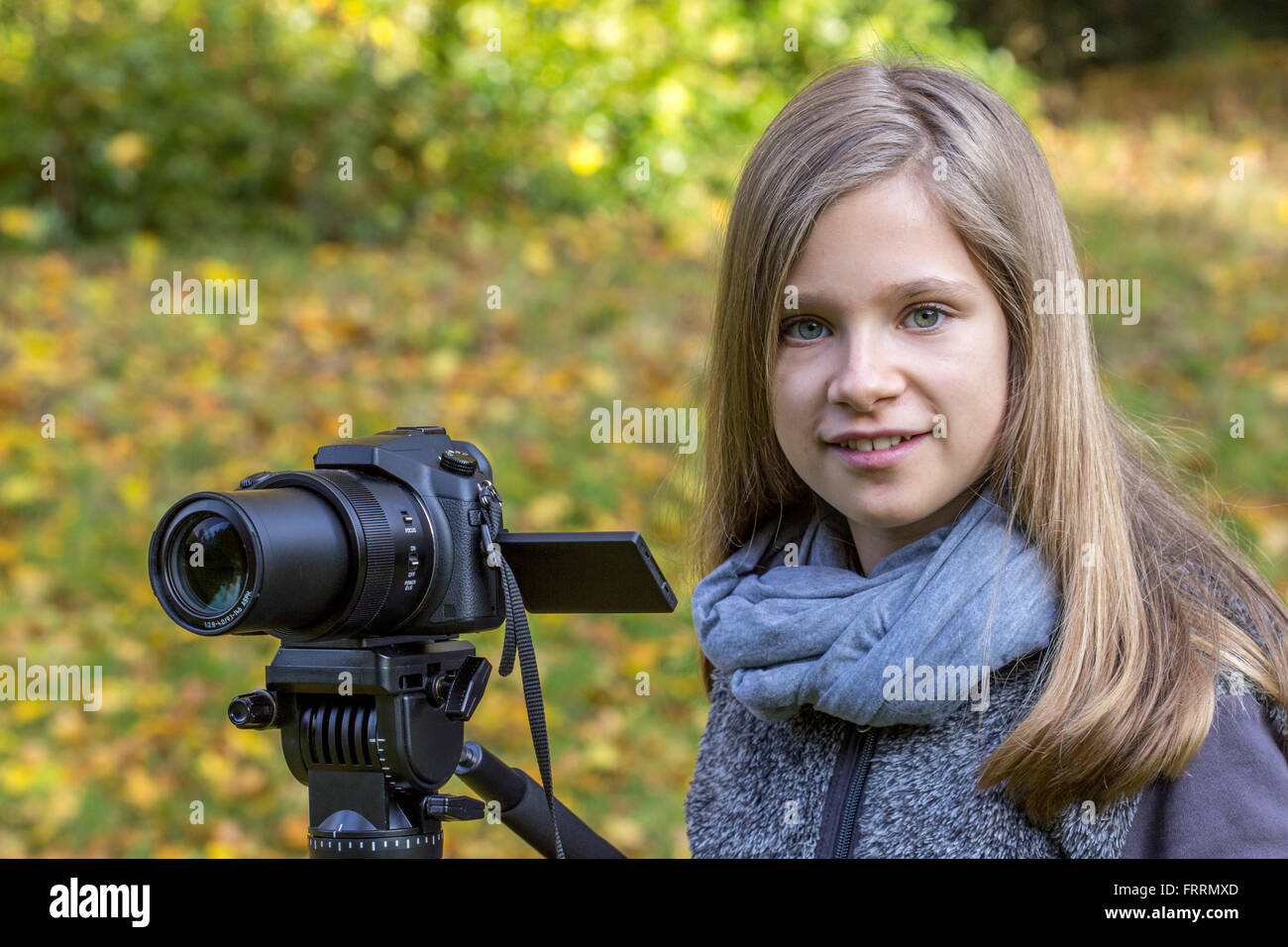 Jeune fille avec un appareil photo sur un trépied Banque D'Images
