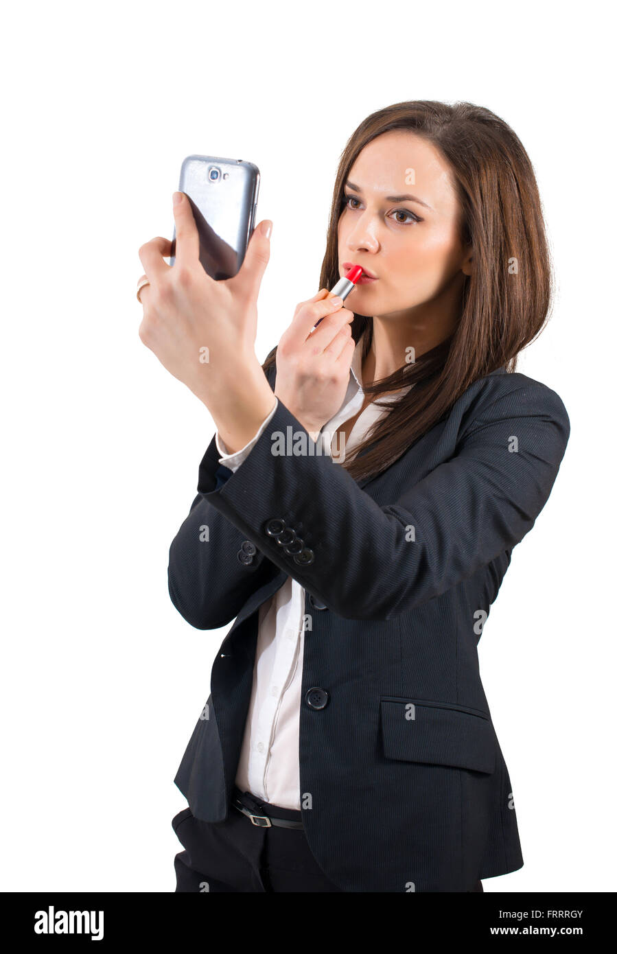 Belle femme qui composent en utilisant son téléphone comme un miroir Banque D'Images