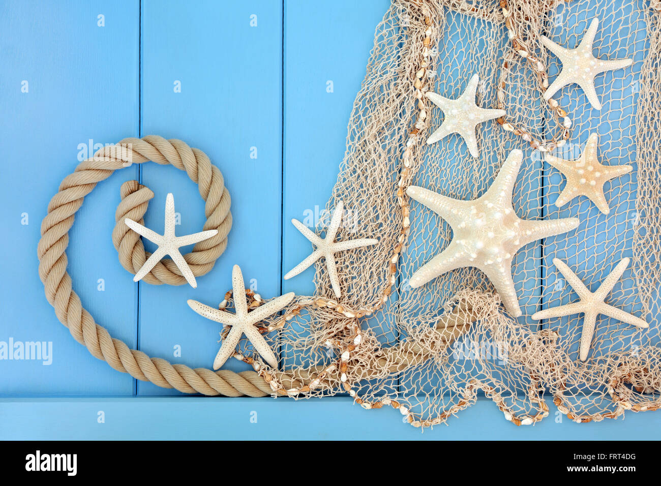 Étoile de seashell collage abstrait avec corde et filet de poisson sur fond bleu en bois. Banque D'Images