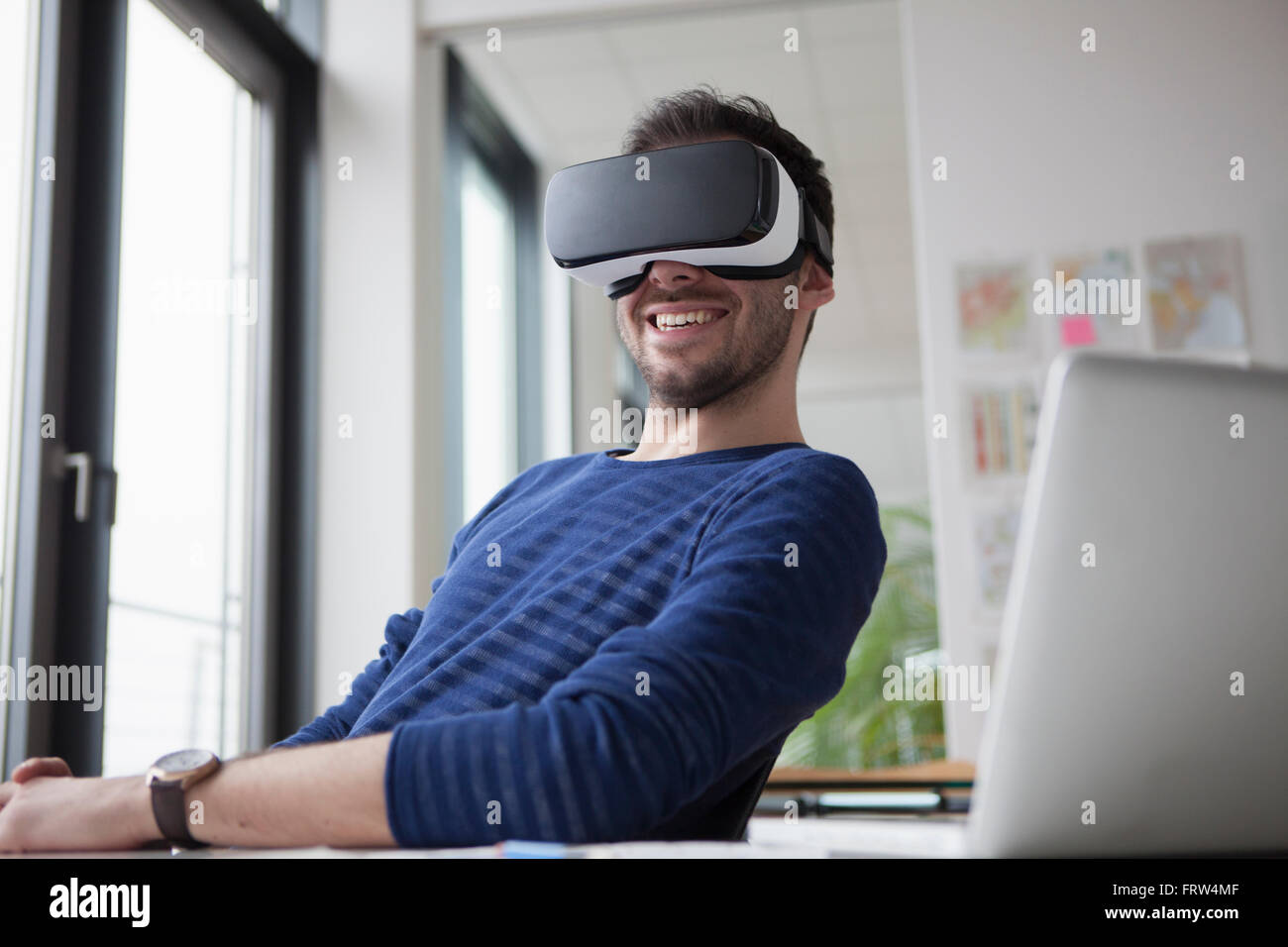 Smiling homme portant des lunettes de réalité virtuelle dans le bureau Banque D'Images