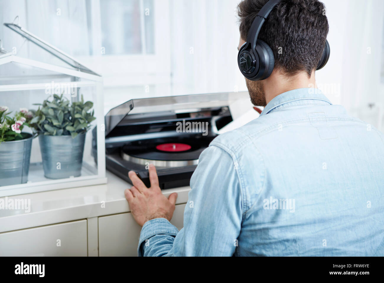 Jeune homme portant des écouteurs à partir record player Banque D'Images