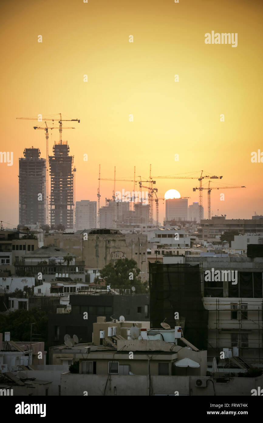 Israël, Tel Aviv, paysage urbain avec des grues au coucher du soleil Banque D'Images