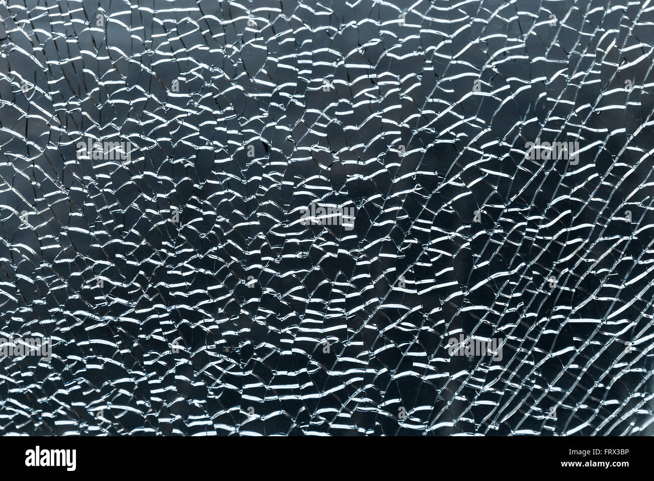 Bris de glace avec des fissures et des fragments sur fond bleu foncé. Photo en gros plan de la texture Banque D'Images